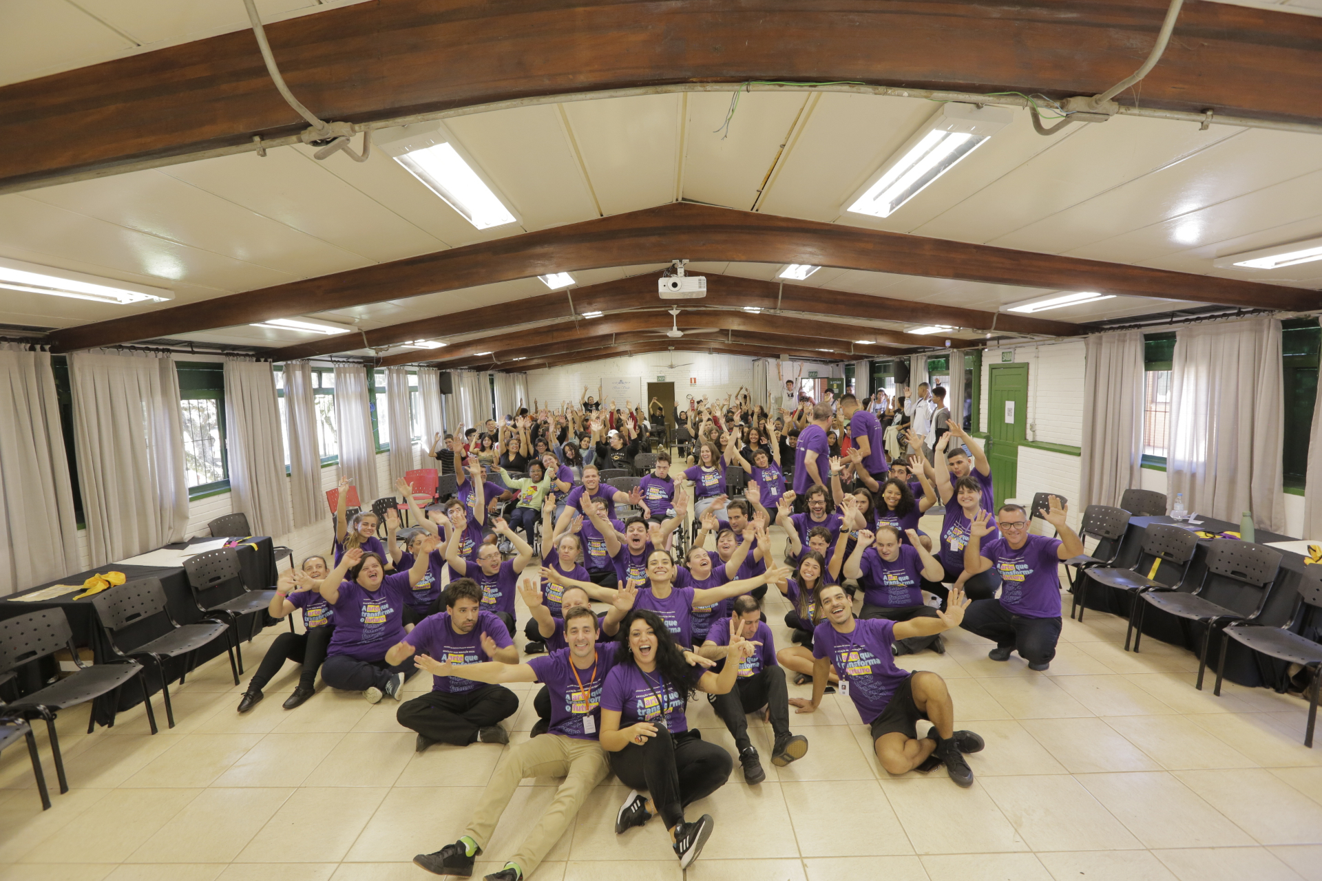 Time Pertence e participantes em foto coletiva, camisetas roxas